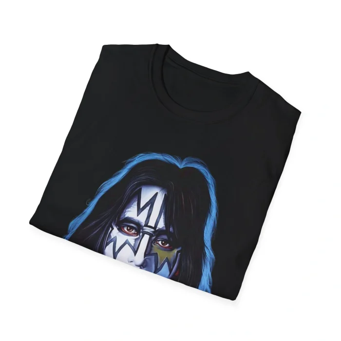 A folded black Ace Frehley Shirt featuring a graphic of a person with long dark hair and white face paint with bold black and blue rock band-inspired designs.