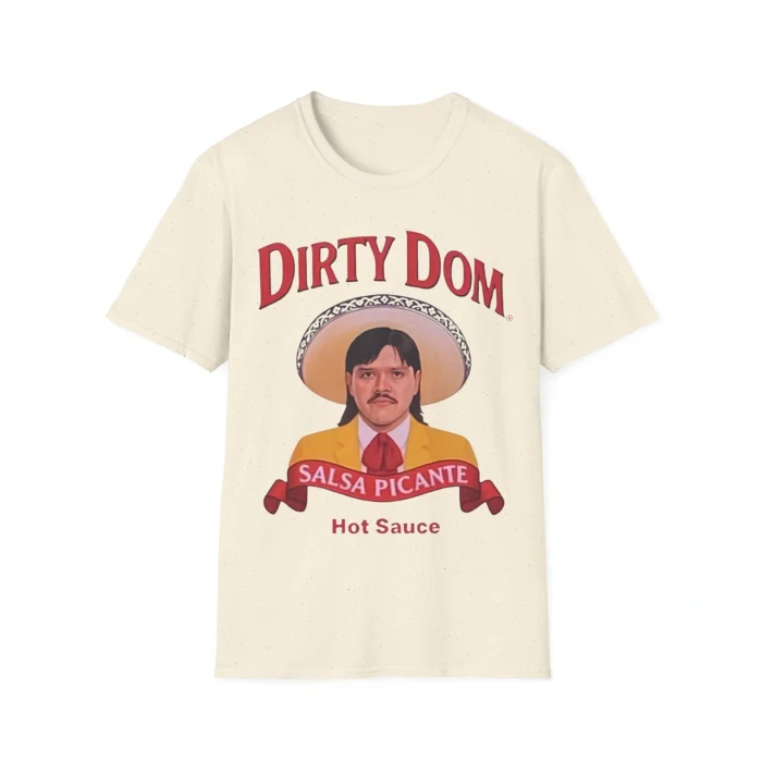 The Dirty Dom Tapatío Shirt is beige and displays a mustached man in a sombrero and yellow suit. Red text reads DIRTY DOM, with SALSA PICANTE and Hot Sauce shown below on a red ribbon.