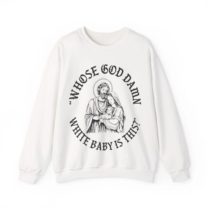 The Whose God Damn White Baby Is This Shirt is white and features a black line drawing of a haloed Mary and Joseph holding baby Jesus, with the text “WHOSE GOD DAMN WHITE BABY IS THIS?” around the illustration.